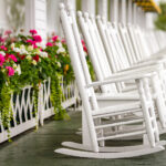 Several White Rocking Chairs on Long Porch just waiting for you to come and enjoy on a luxury trip to Mackinac Island
